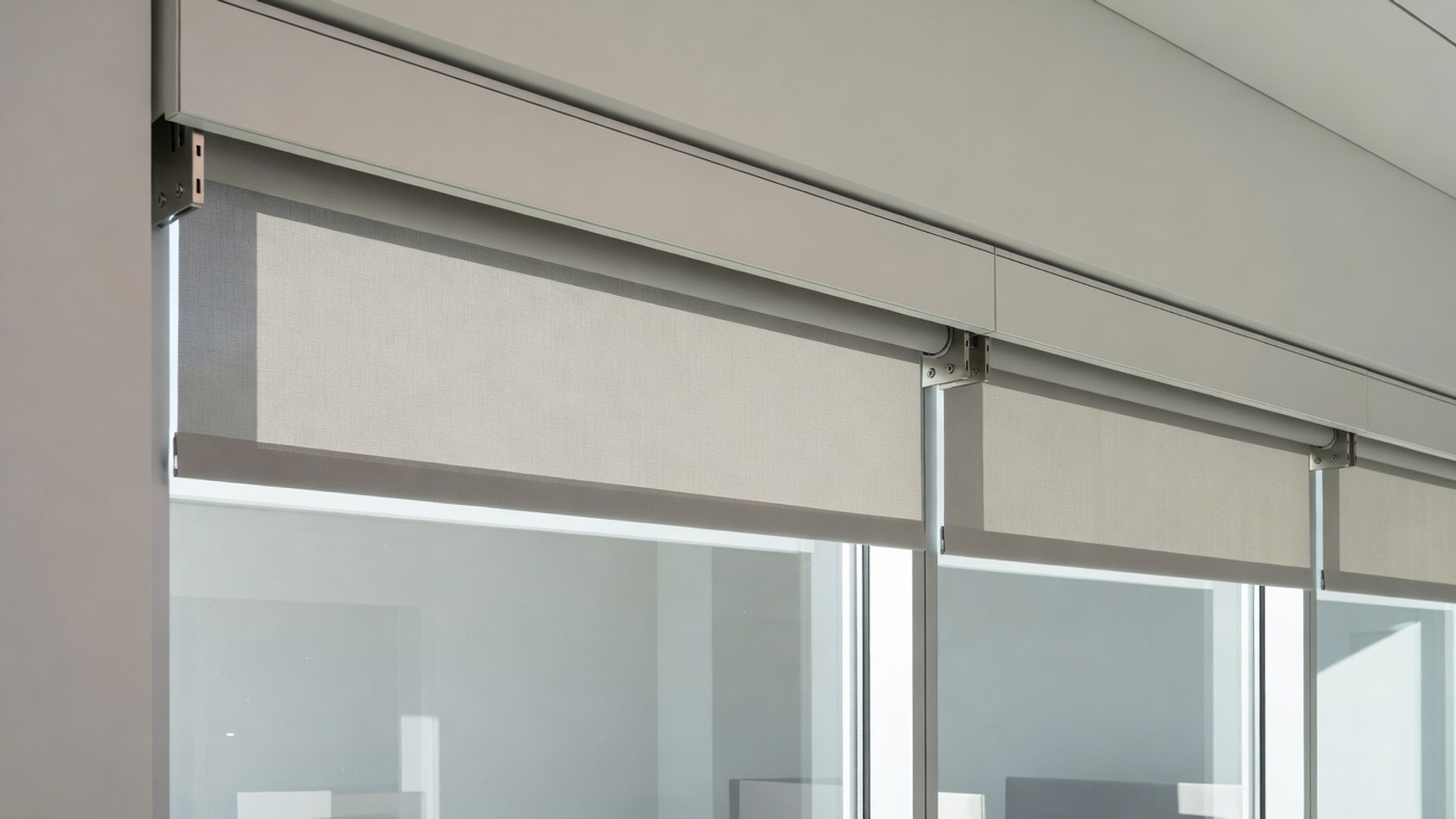 Commercial roller shade bracket and fascia detail on Phoenix office glass.
